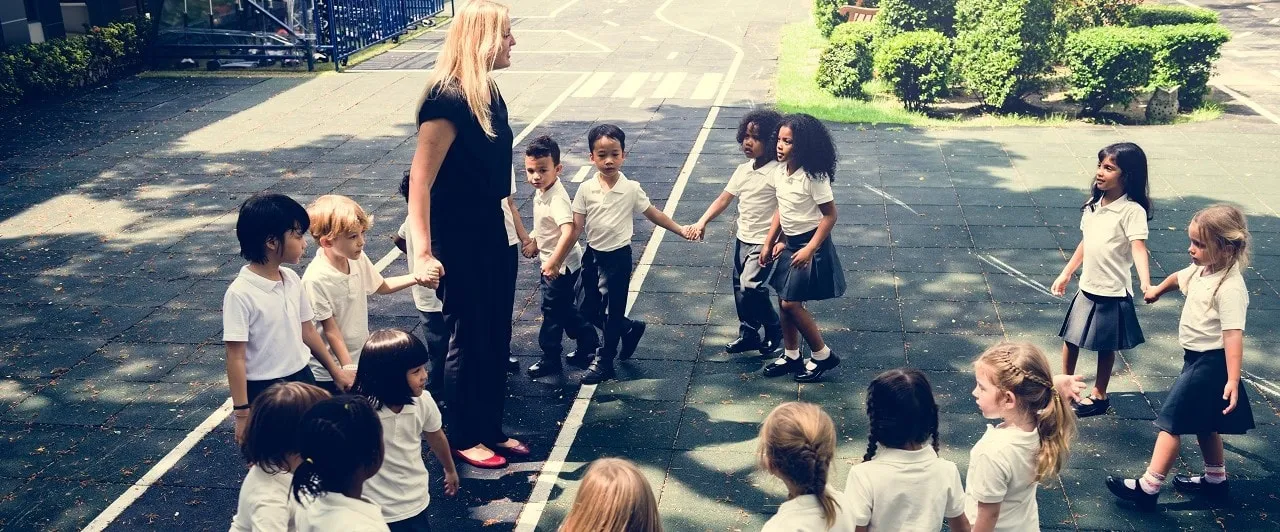 Maestra y niños en círculo tomados de la mano